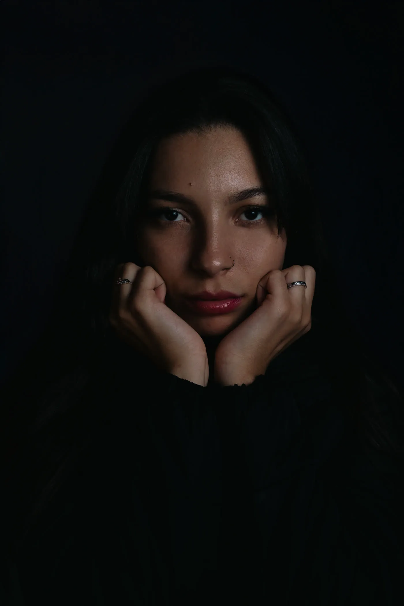 Editorial Portrait, Hände am Gesicht, dunkler Hintergrund, Blick in die Kamera